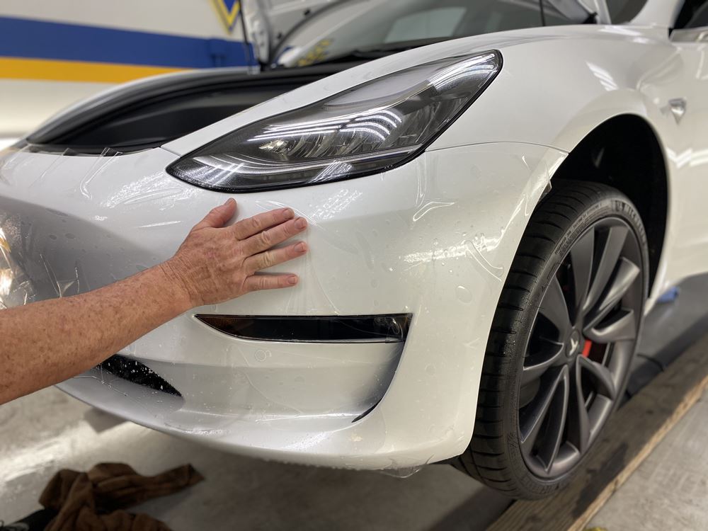 White Tesla applying paint protection film